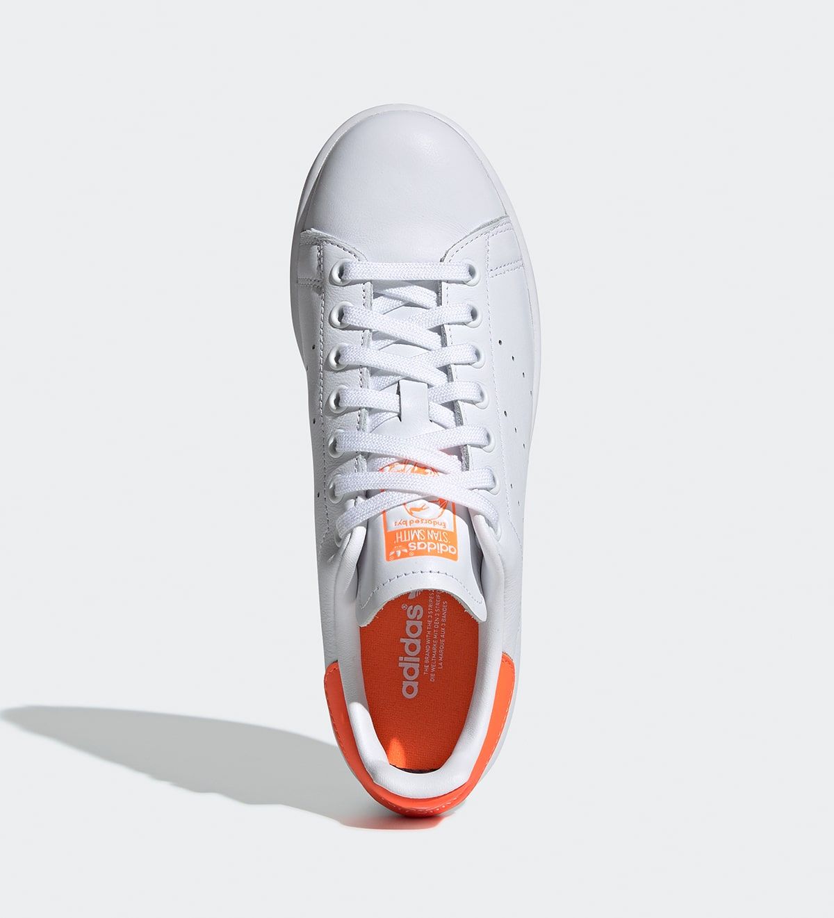 white adidas with orange stripes